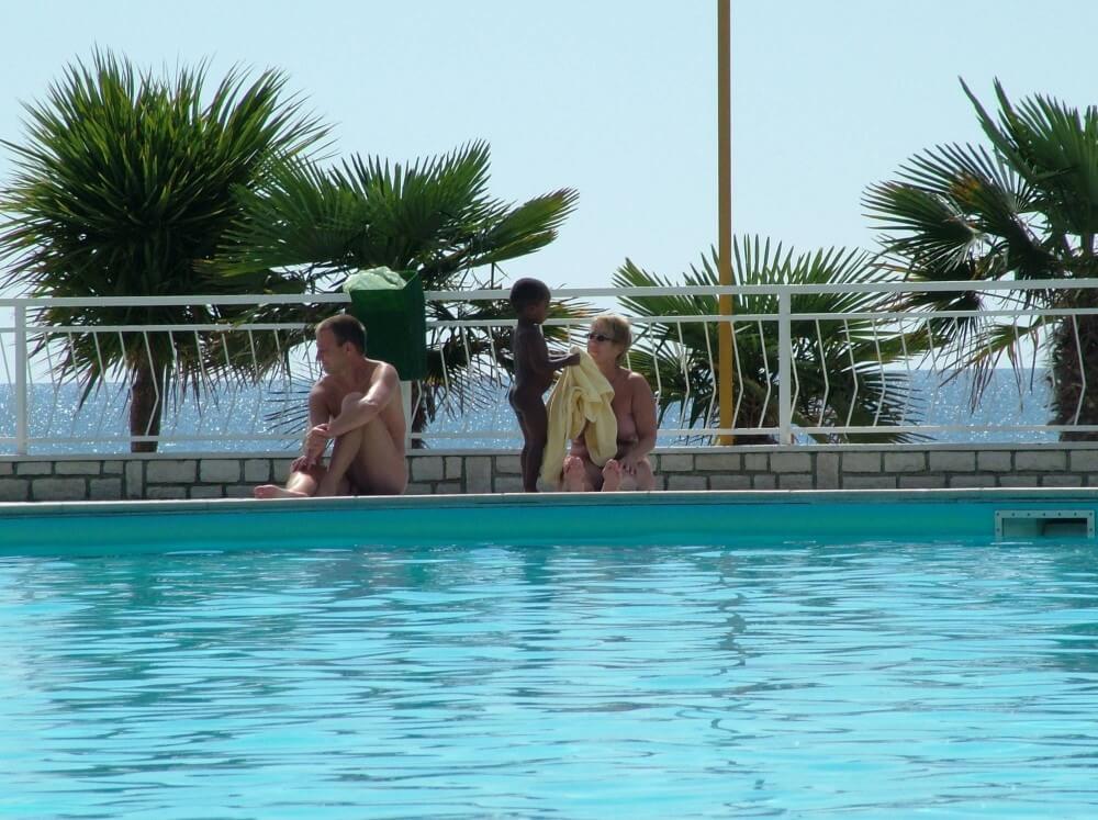 Photo of naturists in an outdoor pool - The benefits of naturist vacations